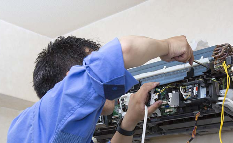 AC technician performing maintenance cleaning on an outdoor compressor unit